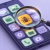 Illustration av en mobiltelefon där ett förstoringsglas upptäcker en skadlig app bland telefonens appar.